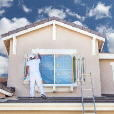 Professional House Painter Painting the Trim And Shutters of A Home.